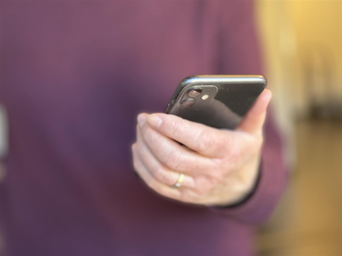 Viser en som leser på mobilen sin - Klikk for stort bilde