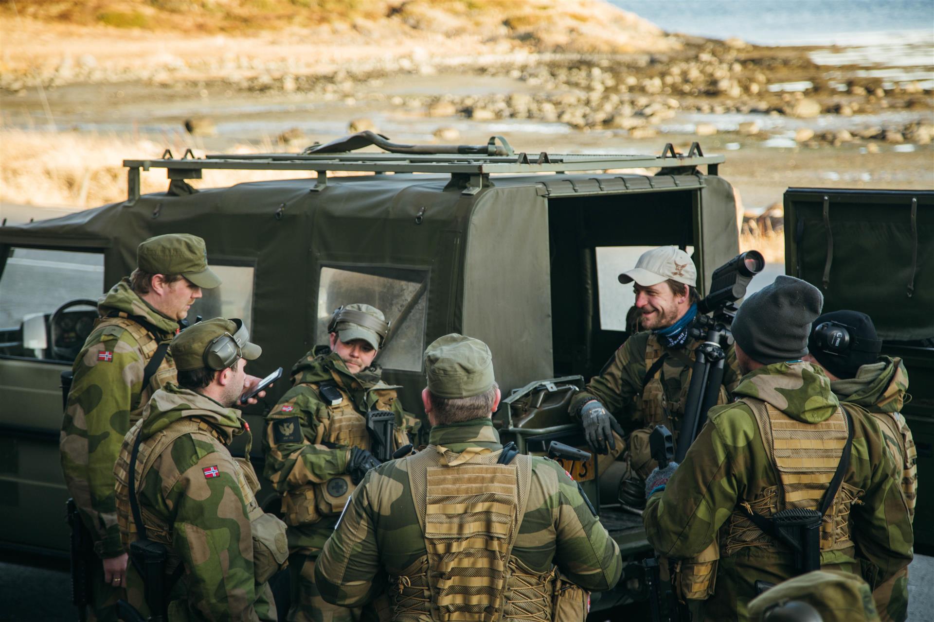 Personell med Militæruniform som står ved militær kjøretøy