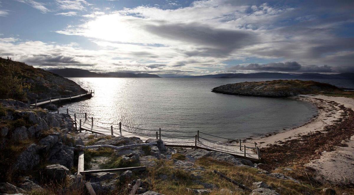 Fjære med sand, tang og berg - Klikk for stort bilde