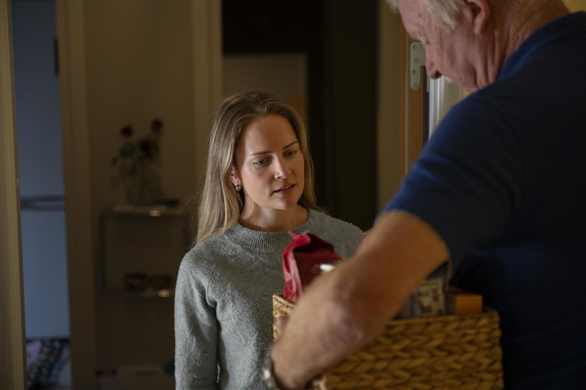 To personer ser på en kurv med kaffe og tørrvarer.  - Klikk for stort bilde